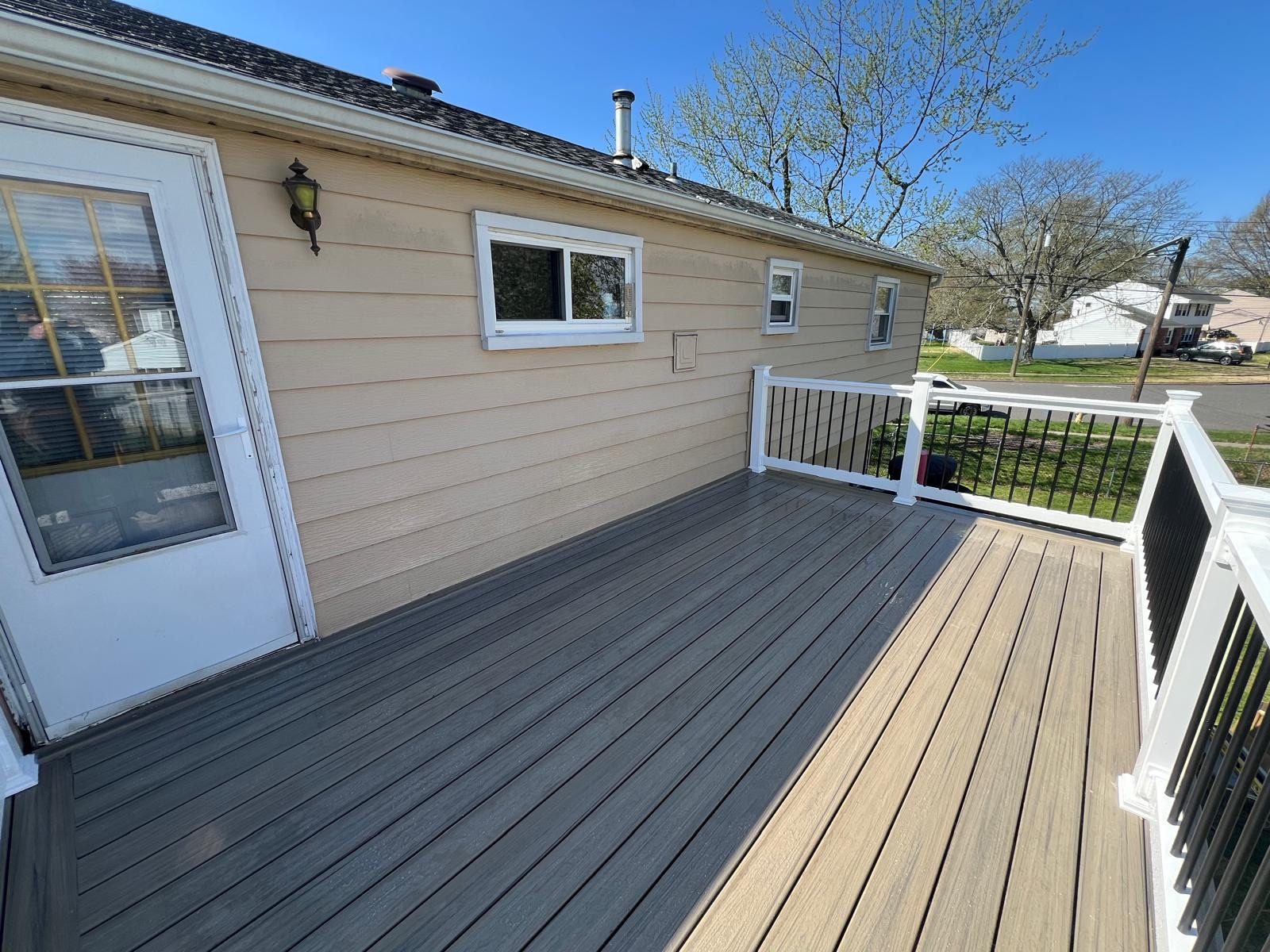 Finished composite deck surface with white and black railings